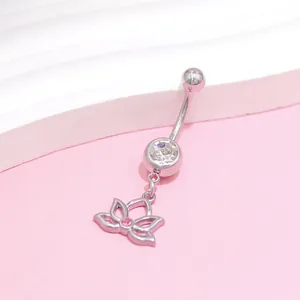 Macro shot of stainless steel belly ring featuring a lotus pendant and pink crystal