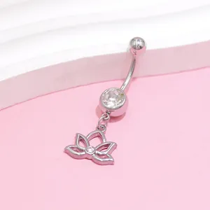 Macro detail of stainless steel belly ring featuring a cutout lotus pendant and zircon