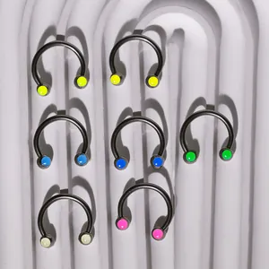Set of 7 titanium steel circular barbells with colorful acrylic ball ends on white surface