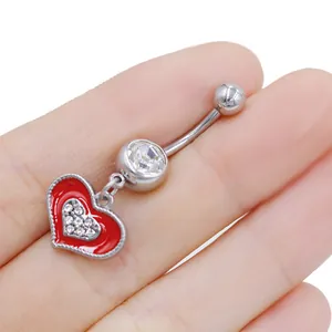 Vista macro del piercing all'ombelico a cuore in acciaio con zirconi e bordo rosso