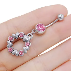 Dettaglio di un piercing all'ombelico in acciaio inossidabile con cuore in cristallo rosa