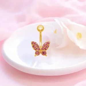 Nahaufnahme der Bauchnabelpiercing-Schleife mit rosa Kristallen und goldenem Titanstab