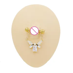 Detailed close-up of golden nipple ring featuring a rectangle zircon and wing design