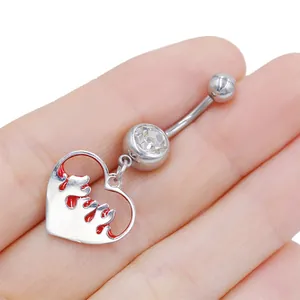 Dettaglio di un piercing all'ombelico in acciaio inossidabile con cuore e smalto rosso