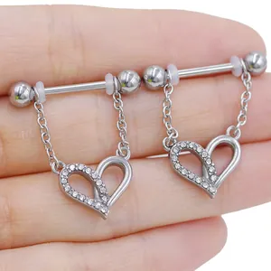 Detail of heart-shaped barbell nipple rings with sparkling crystals and silver chain link