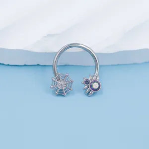 Detailed close-up of a horseshoe septum ring featuring a spider and iridescent gem web
