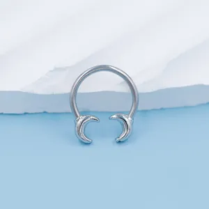 Macro shot of silver horseshoe septum ring featuring crescent moon ends in a polished finish