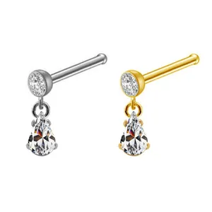 Detail of silver and gold nose studs featuring hanging teardrop-shaped zircons