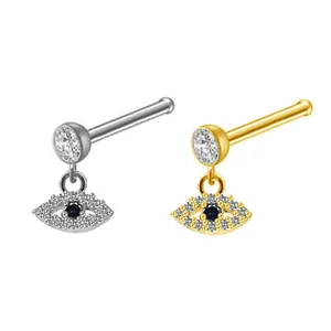 Macro view of gold and silver Evil Eye nose studs with blue stones and zircons