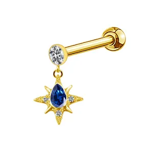 Detailed close-up of gold starburst stud earring with teardrop blue stone and zircon