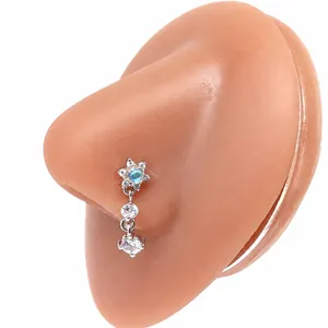 Dettaglio del piercing al naso a forma di stella con zircone azzurro e pendenti in cristallo