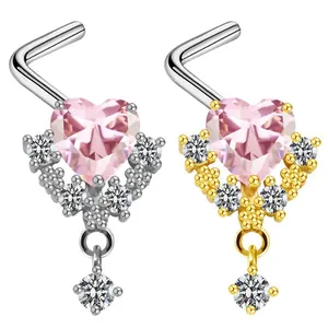 Dettaglio di piercing al naso a cuore con zircone rosa e pendente in oro e argento