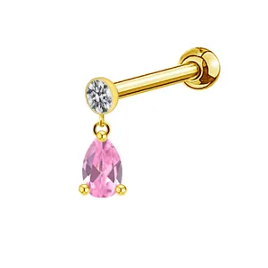 Detail of gold piercing stud featuring clear round stone and pink teardrop gemstone