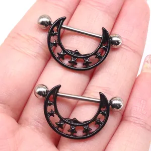 Black moon and star cutout nipple rings made of stainless steel displayed on hand