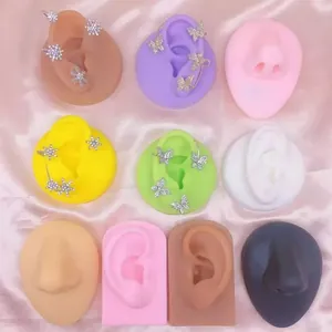 Detailed view of rhinestone butterfly and snowflake earrings on colorful silicone ear models