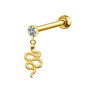 Macro detail of golden snake charm labret with sparkling round white gemstone stud