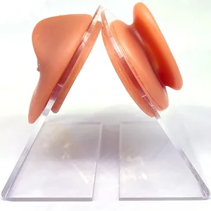 Detail view of realistic silicone breast forms on transparent acrylic display stands