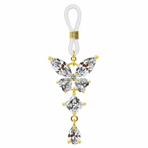 Détail d'un pendentif papillon doré avec zircons et boucle en silicone ajustable