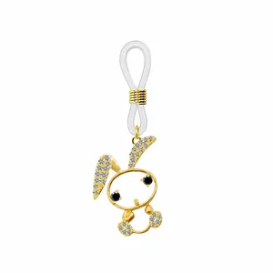 Détail macro du pendentif lapin doré avec zircons blancs et boucle en silicone