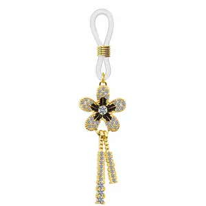 Vue détaillée du connecteur de chaîne à lunettes doré avec fleur strass et émail noir