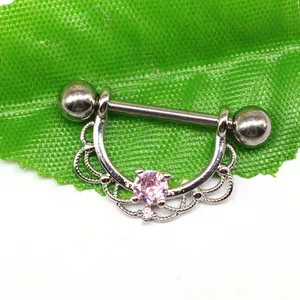 Macro shot of silver nipple piercing jewelry with pink zircon and lace detail