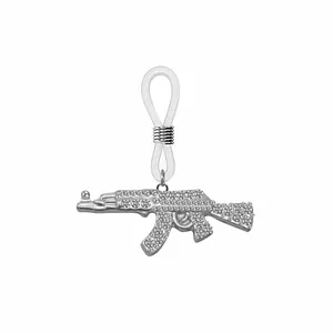Détail macro du pendentif pistolet AK-47 argenté orné de zircons blancs brillants