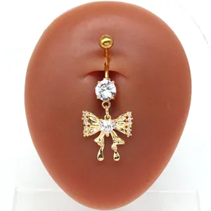 Detailansicht eines goldenen Bauchnabelpiercings mit Kristallschleife auf Hautmodell