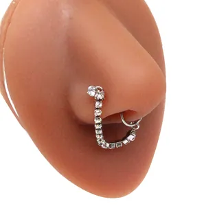 Detail of a sparkling heart nose ring chain in silver with white cubic zirconia stones