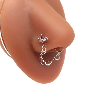 Detail of silver nose ring chain with pink heart gems on a silicone nose model