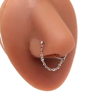 Detail of stainless steel heart nose stud and ring combo with a fine connecting chain