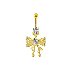 Detailansicht eines goldenen Bauchnabelpiercings mit Schmetterling und Herzanhänger