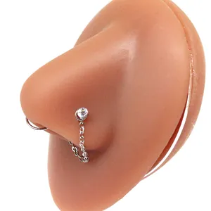 Detail of silver stainless steel nose ring chain with a sparkling clear cubic zirconia