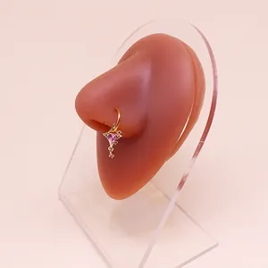 Dettaglio dell'anello al naso a stella dorata con cuore rosa su modello in silicone