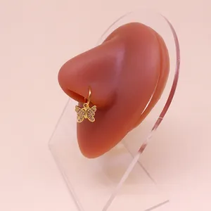 Dettaglio macro di un anello al naso a farfalla dorato con cristalli rosa su un modello