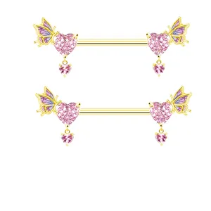 Dettaglio di piercing per capezzoli dorati con ali di farfalla e cristalli a cuore rosa