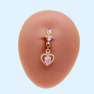 Detailansicht goldener Bauchnabelpiercing mit rosa Zirkonia auf Silikonmodell