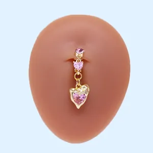 Nahaufnahme von goldenem Bauchnabelpiercing mit rosa Herz-Steinen am Model