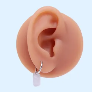 Dettaglio orecchino minimalista con cerchio in argento e ciondolo a cilindro in cristallo bianco