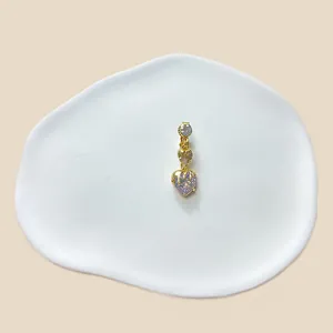 Detailansicht Bauchnabelpiercing mit fliederfarbenen Herzsteinen und goldenem Schmelzeffekt