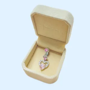 Makro-Detail von silbernem Herz-Bauchnabelpiercing mit rosa Zirkon in Samtbox
