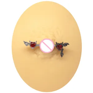 Detail of red heart nipple ring with asymmetric angel wings and devil wing design
