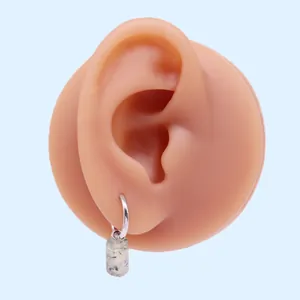 Orecchino a cerchio minimalista in argento con ciondolo rettangolare su sfondo blu chiaro