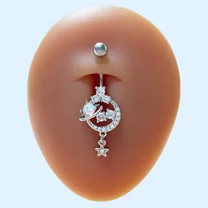Detalle de piercing de ombligo con planeta de ópalo y estrella de circón en un modelo
