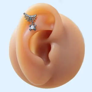 Macro view of a black spiderweb cartilage stud earring with heart-shaped gemstone drops