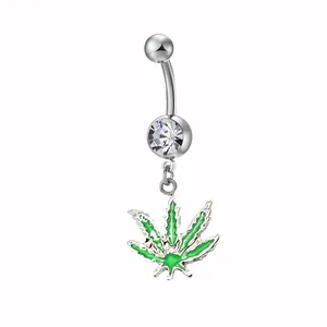 Dettaglio macro del piercing all'ombelico in argento con foglia di cannabis verde