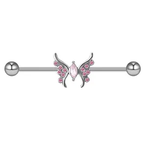 Macro detail of industrial barbell earring with pink butterfly and zircon stones