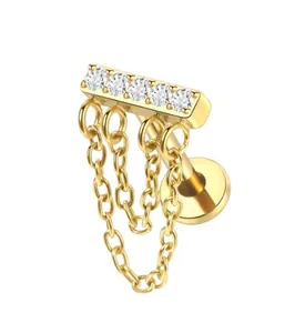 Detailed macro view of gold labret stud featuring 5 zircon stones and dual hanging chains