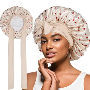 Beige satin sleep bonnet with cherry print and long ties for hair protection