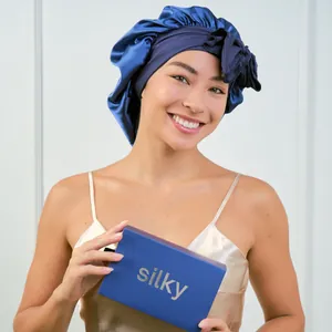 Premium navy blue silk sleep bonnet with bow detail and elegant gift box packaging