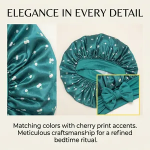 Teal satin sleep bonnet with white cherry print and elegant bow detail for hair care